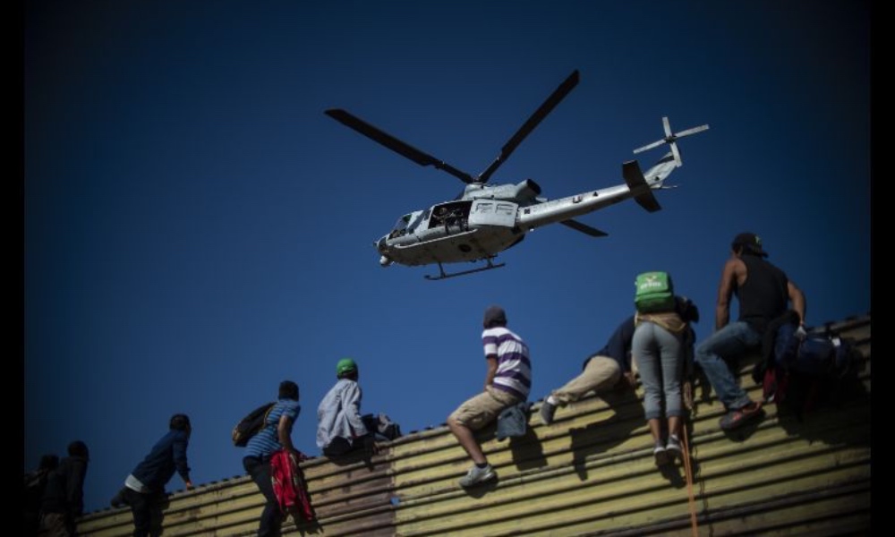 migrantes-intentan-cruzar-a-la-fuerza-el-muro-fronterizo-en-tijuana